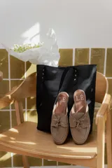 Mules de gamuza color tostado con diseño de zapato náutico, con cordones frontales y plantilla con logo estampado.