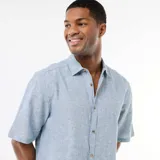 Camisa de manga corta celeste melange, confeccionada en mezcla de lino, con cuello camisero y cierre frontal de botones.