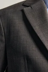 Blazer regular fit de Zara, confeccionada en tejido gris con mezcla de lana, con solapas de muesca, cierre de botonadura frontal y bolsillos con solapa en la cadera.