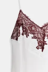 Vestido midi blanco de la ZW Collection con escote en V, tirantes finos, bajo asimétrico y detalle de aplicación de encaje a contraste en el escote.