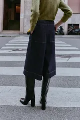 Bermuda de tiro alto en denim azul oscuro, corte ancho tipo culotte, con pinzas delanteras y pespuntes en color caramelo.