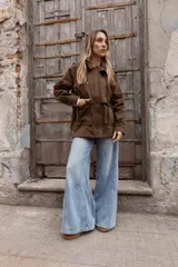Gabardina liviana color beige con capucha, cierre frontal oculto y cintura ajustable mediante cordón. Presenta bolsillos delanteros amplios y mangas largas con puños rectos.