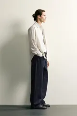 Camisa relaxed fit de algodón con estructura, cuello solapa, manga larga con puño abotonado, bolsillo de parche en el pecho y cierre frontal con botones. Presenta diseño de rayas finas.