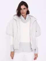 Campera corta color beige con capucha, cierre frontal con cremallera y mangas cortas. Diseño acolchado con patrón de rombos.