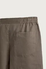 Bermuda de lino negro de corte relaxed fit, con cintura elástica ajustable mediante cordón y bolsillos frontales.