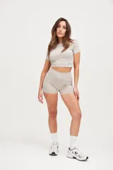 Calza corta color beige, de tiro medio y corte ajustado.