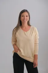 Sweter de escote en V y manga larga, confeccionado en tejido de viscosa. Presenta un diseño en color crudo con estampado de rayas verticales y detalles en color oro.