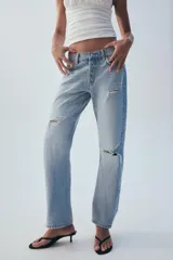 Jeans rectos de tiro medio en denim azul con efecto deslavado. Presentan diseño de cinco bolsillos, cierre frontal con botones metálicos y dobladillo vuelto en el bajo.