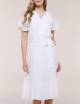 Vestido midi blanco de calce suelto y caída fluida, con escote en V, cuello a la base y apertura abotonada con detalle de puntilla. Cuenta con cintura elastizada con lazo para anudar a tono, mangas cortas con volados y falda con volantes escalonados.