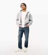 Pantalón de jean Blue Steel con corte slim, confeccionado en algodón con un toque de elastano. Presenta un lavado azul medio con sutiles efectos de desgaste localizados, cierre frontal con botón y cremallera, y bolsillos funcionales.