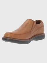 Zapato tipo mocasín de cuero color tostado, con diseño de costuras reforzadas y suela de goma EVA en color negro.