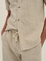 Short de lino y algodón a rayas beige con un toque plateado, con cintura elástica y cordón de algodón, y bolsillos laterales.
