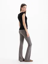 Pantalón Margot de microfibra negra, de tiro alto y silueta ajustada con botamangas acampanadas y tajos laterales.