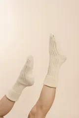 Medias tejidas a máquina en punto elástico, color crudo. Confeccionadas en lana fina sin teñir.