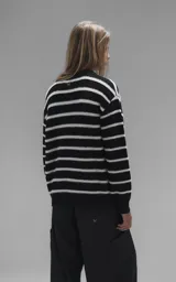 Sweater de cuello redondo con diseño de rayas horizontales en blanco y negro. Confeccionado en tejido de punto con textura suave, corte oversize y terminaciones en punto rib en cuello, puños y ruedo.