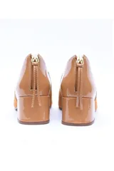 Zapato de tacón cuadrado color camel, confeccionado en una combinación de cuero nobuck y napa. Presenta un diseño de punta cuadrada, cierre trasero con tirador metálico dorado y taco forrado de 5 cm.
