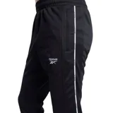 Pantalón de jogging negro con cintura elástica, corte ajustado y logo de Reebok estampado en blanco. Presenta una franja blanca vertical a lo largo de la pierna.