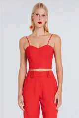Top estilo corset de color rojo, con escote corazón y tirantes finos. Presenta un diseño estructurado y ajustado al cuerpo.