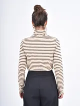 Polera de manga larga en color tostado, confeccionada en tejido suave con cuello alto tipo tortuga.