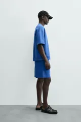 Bermuda de algodón color beige claro, corte relajado (relaxed fit), con cintura elástica ajustable mediante cordón y bolsillos laterales y trasero de plastrón.