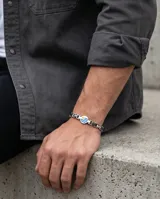 Pulsera de eslabones de acero antialérgico con dije central circular esmaltado con la bandera de Uruguay.