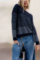 Sweater color crema con rayas horizontales y mangas largas.