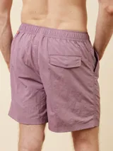 Short de baño de color liso con cintura elástica ajustable mediante cordón y detalle de parche con logo en la parte inferior.