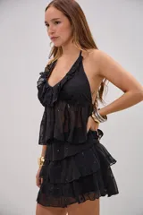 Top negro de chifón con diseño de volados escalonados, escote halter y bordados florales sutiles con lentejuelas.