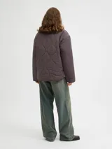 Campera acolchada de color gris oscuro, con diseño matelaseado de ondas, cuello alto en rib, cierre frontal con cremallera metálica y bolsillos frontales aplicados.