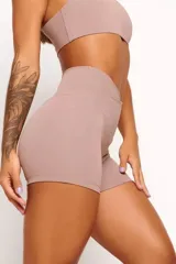 Short deportivo color nude, de tiro alto y corte ajustado. Presenta cintura cruzada en forma de V.