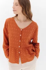 Camisa color crema con bordados florales, escote en V, mangas largas y cierre frontal con botones.