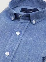 Camisa de lino celeste de manga larga con cuello abotonado y cierre frontal de botones.