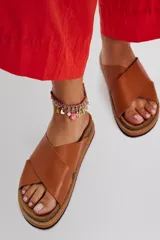 Sandalias planas modelo Santa Fe con tiras cruzadas de cuero negro, plantilla anatómica de corcho y suela de goma.