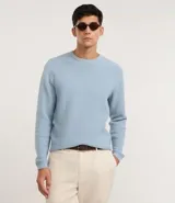Suéter de punto con textura maquinetada, cuello redondo y manga larga. Presenta un diseño clásico y versátil, ideal para un look elegante y cómodo.