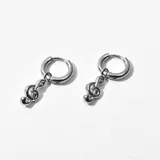 Aros de acero plateado con forma de clave de sol colgando de un aro pequeño.