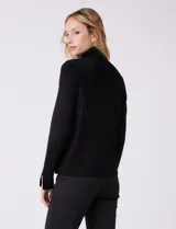 Polera de tejido fino, color rosado, con cuello alto, manga larga y detalle de tajo en los puños.