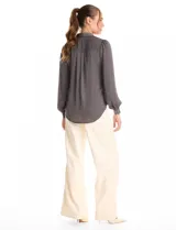 Camisa de satén color celeste, con cuello clásico, cierre frontal con botones y mangas largas con puños abotonados.