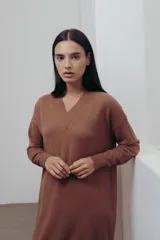 Vestido de punto color marrón, con escote en V, mangas largas y silueta recta con tajos laterales.