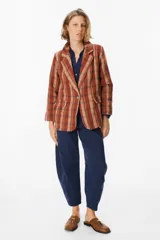 Blazer de corte recto con estampado de cuadros en tonos marrones, beige y rojos. Presenta solapas clásicas, cierre frontal con un botón y bolsillos laterales con solapa.