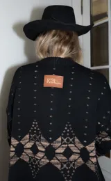 Saco de punto gris con diseño geométrico en color amarillo, cierre frontal con botones, cuello redondo y bordado de corazón pequeño en el pecho.