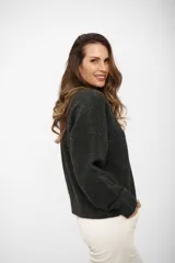 Buzo de punto color gris oscuro, con escote en V, manga larga y hombros caídos. Presenta un diseño holgado con terminaciones acanaladas en puños y ruedo.