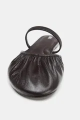 Bailarina destalonada de cuero color marrón oscuro, con detalle fruncido en la puntera redondeada y tira elástica sobre el empeine.