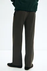 Pantalón de vestir marrón oscuro con microestampado a cuadros, corte relajado y pierna recta. Presenta pinzas frontales y bolsillos al bies.