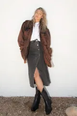 Falda midi de denim gris con lavado gastado, diseño de corte recto con cierre frontal de botones metálicos y tajo central.