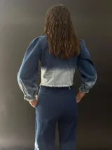 Campera de jean azul con lavado artesanal, entallada y corta hasta la cintura alta. Presenta textura central en el delantero.