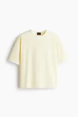 Remera de algodón en punto liviano, con diseño boxy de corte holgado. Presenta cuello redondo acanalado y ribetes en contraste en cuello y mangas, con hombros caídos y bajo recto.