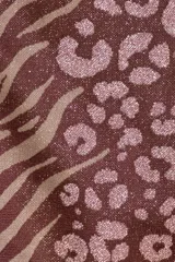 Bombacha de bikini marrón con estampado animal print, cobertura media y detalle de cinturón con dije de tigre.