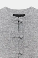 Chaqueta de punto gris con cuello redondo, manga larga y cierre frontal mediante alamares.