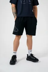 Short negro oversize con logo triangular estampado en gris en la pierna izquierda.