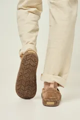 Championes slip-on color arena, con capellada de gamuza y elásticos laterales negros. La suela es fina, flexible y plana, con un diseño que simula corcho.